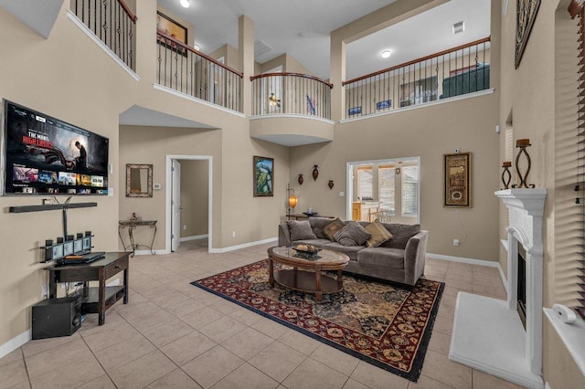 living room featuring tile patterned flooring, visible vents, a fireplace, and baseboards