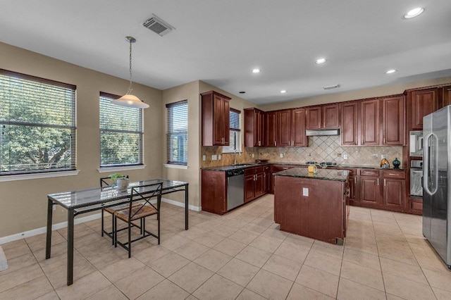 kitchen with under cabinet range hood, visible vents, appliances with stainless steel finishes, and decorative backsplash