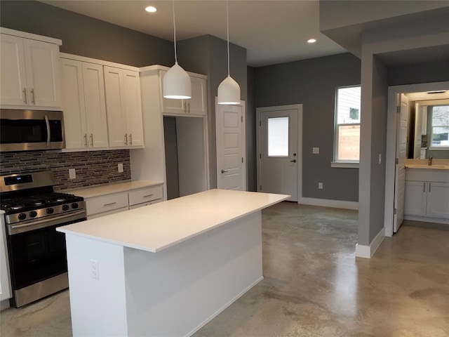 kitchen with a kitchen island, backsplash, stainless steel appliances, light countertops, and baseboards