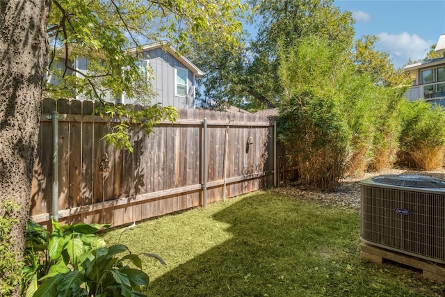 view of yard with central air condition unit and fence