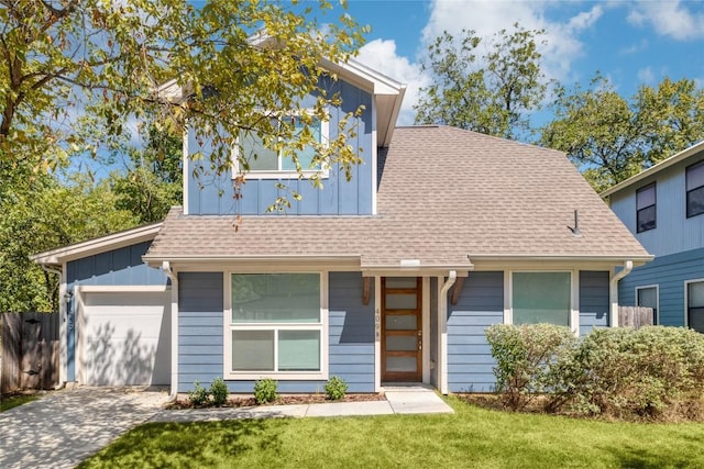 view of front of house featuring a front yard, roof with shingles, concrete driveway, a garage, and board and batten siding