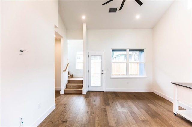 foyer entrance featuring stairway, baseboards, visible vents, and wood finished floors