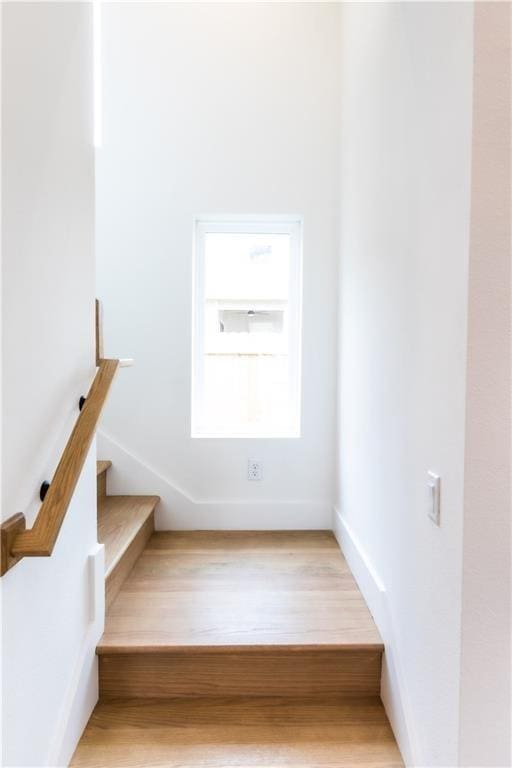 staircase with wood finished floors and baseboards