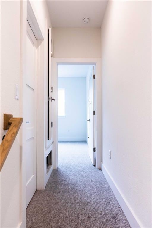 corridor featuring carpet flooring and baseboards