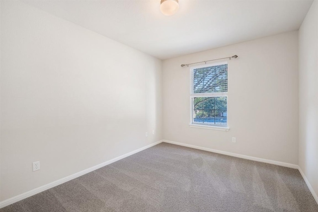 spare room with carpet and baseboards