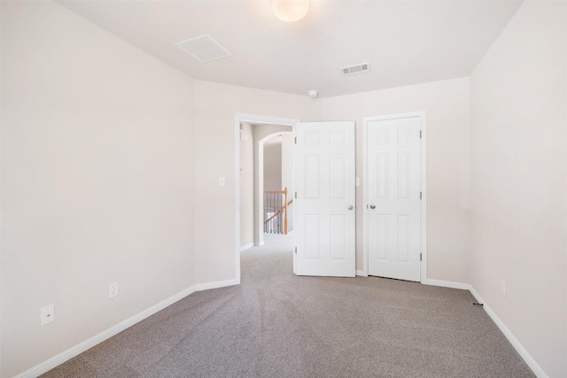 unfurnished bedroom with carpet, baseboards, and visible vents