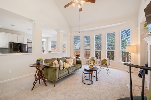 living area featuring visible vents, high vaulted ceiling, decorative columns, ceiling fan, and light carpet