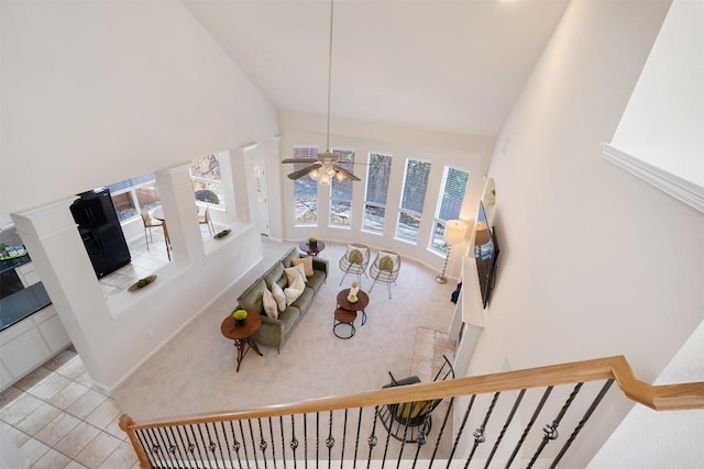 living room featuring carpet floors, high vaulted ceiling, and stairs