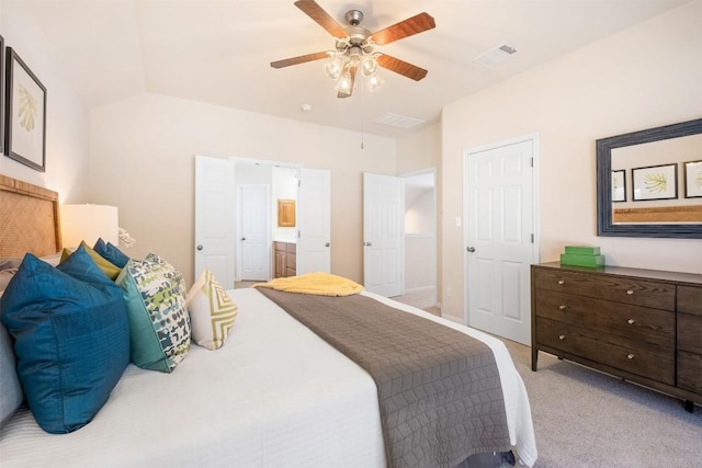 bedroom featuring a ceiling fan, visible vents, ensuite bath, lofted ceiling, and light carpet