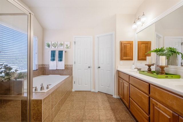 full bath with a sink, a garden tub, and double vanity