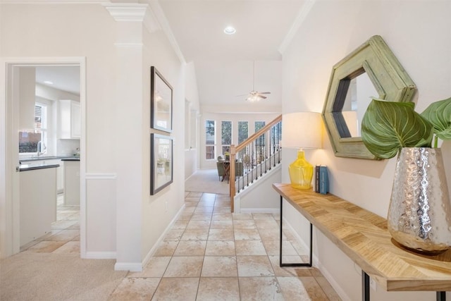 corridor with stairs, baseboards, light tile patterned flooring, and crown molding