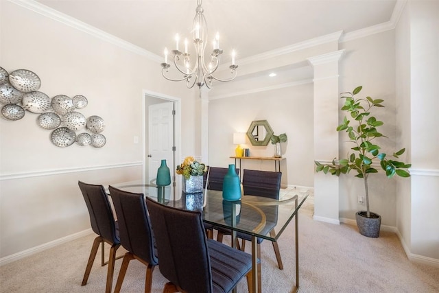 carpeted dining area featuring a notable chandelier, baseboards, crown molding, and ornate columns