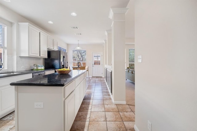 kitchen featuring a kitchen island, a sink, white cabinets, black fridge with ice dispenser, and stainless steel dishwasher