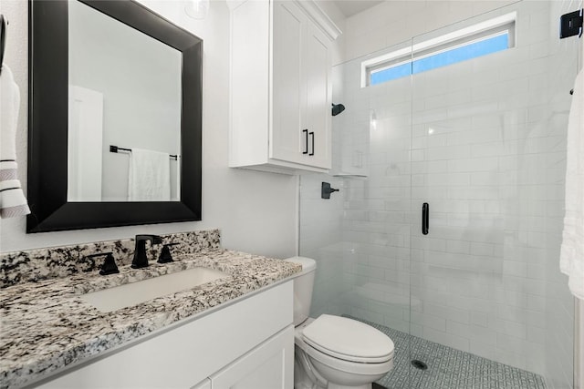 bathroom featuring toilet, a stall shower, and vanity