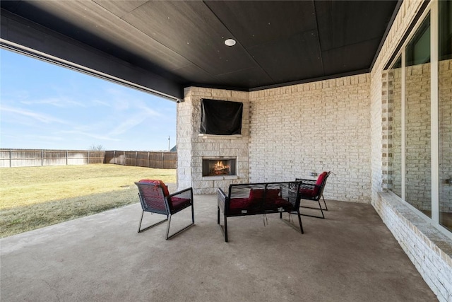 view of patio featuring an outdoor stone fireplace and a fenced backyard