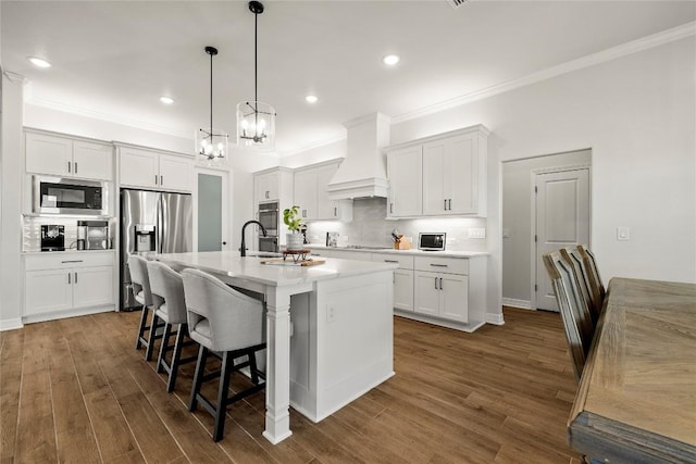 kitchen with a breakfast bar, custom exhaust hood, dark wood-type flooring, and appliances with stainless steel finishes