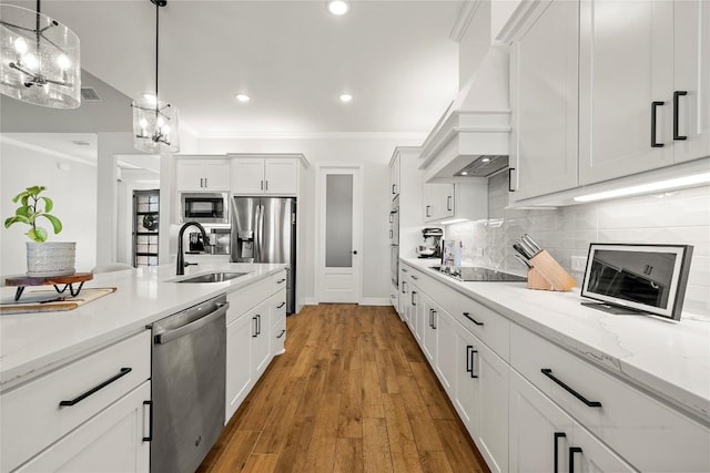 kitchen featuring custom range hood, a sink, backsplash, stainless steel appliances, and crown molding