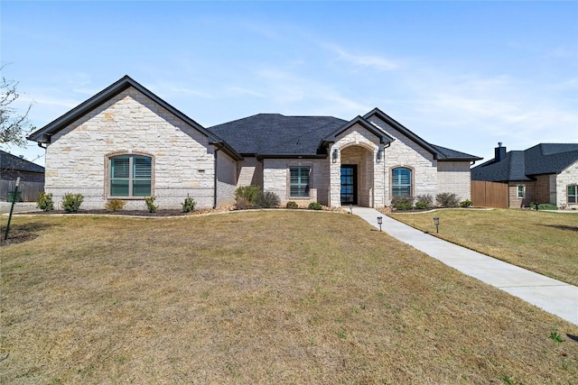 french provincial home with a front yard