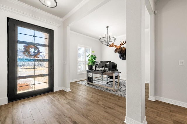 entrance foyer featuring ornamental molding, an inviting chandelier, baseboards, and wood finished floors