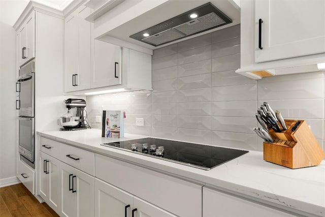 kitchen featuring white cabinetry, black electric cooktop, dark wood-style floors, and premium range hood