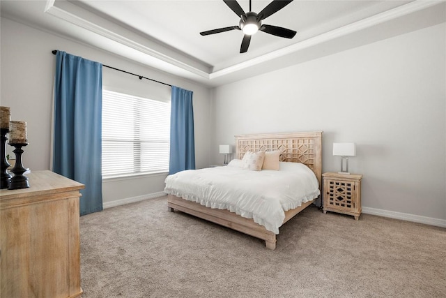 bedroom featuring a tray ceiling, carpet flooring, baseboards, and ceiling fan