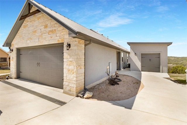 view of front of property featuring a garage, stone siding, and stucco siding