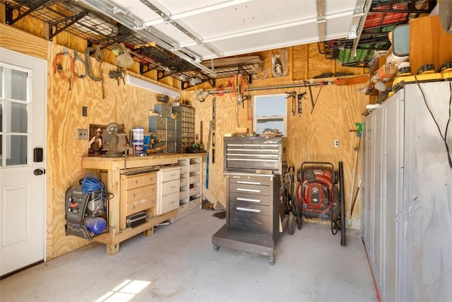 garage featuring a workshop area and wood walls