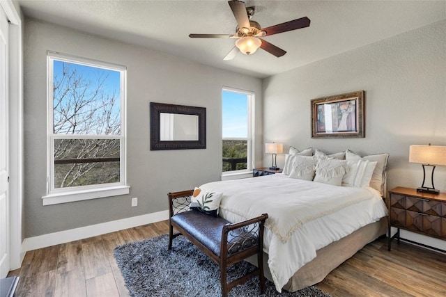 bedroom featuring ceiling fan, baseboards, and wood finished floors