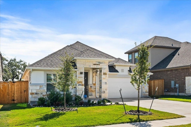 french country home featuring stone siding, fence, concrete driveway, a front yard, and a garage