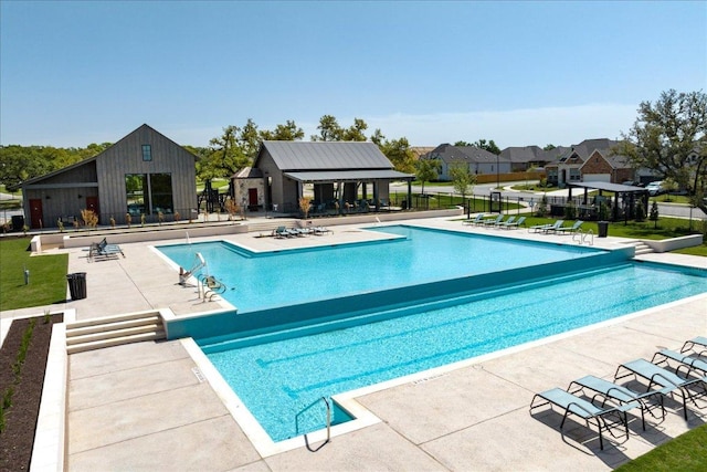 community pool with a patio area and fence