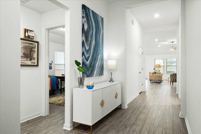 hallway featuring wood finished floors and baseboards