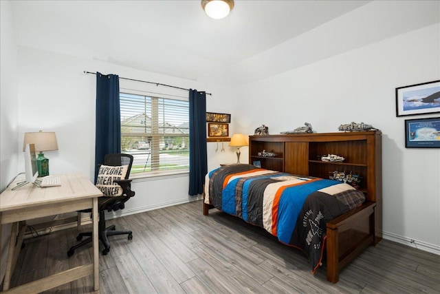 bedroom featuring baseboards and wood finished floors