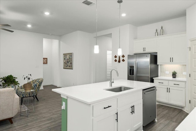 kitchen featuring wood finished floors, visible vents, a sink, appliances with stainless steel finishes, and tasteful backsplash