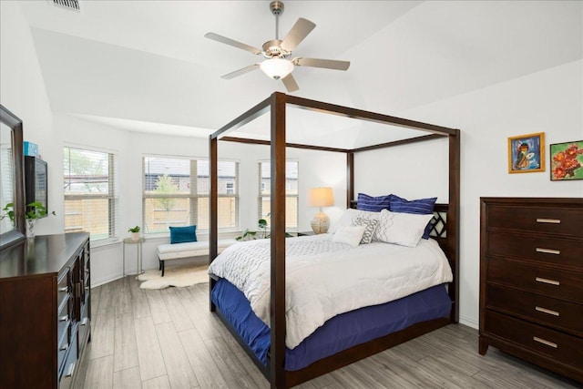 bedroom featuring a ceiling fan, lofted ceiling, and wood finished floors