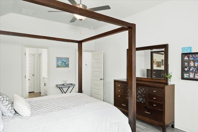 bedroom featuring ensuite bath and light wood-style floors