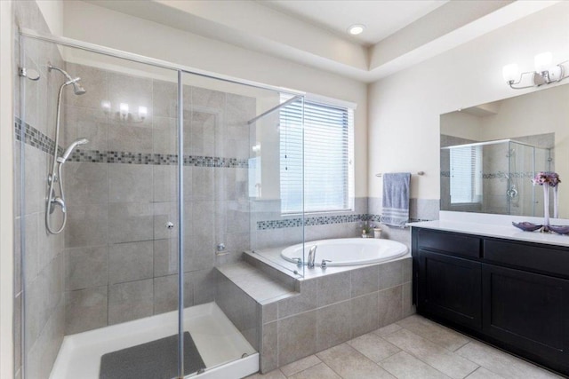 bathroom featuring tile patterned flooring, a garden tub, vanity, and a stall shower