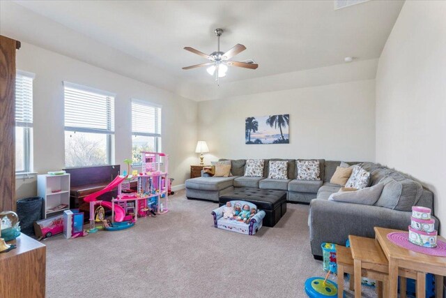 carpeted living room featuring baseboards and a ceiling fan