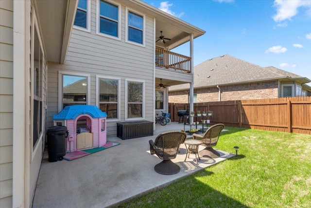 back of property featuring a balcony, fence, a yard, ceiling fan, and a patio area