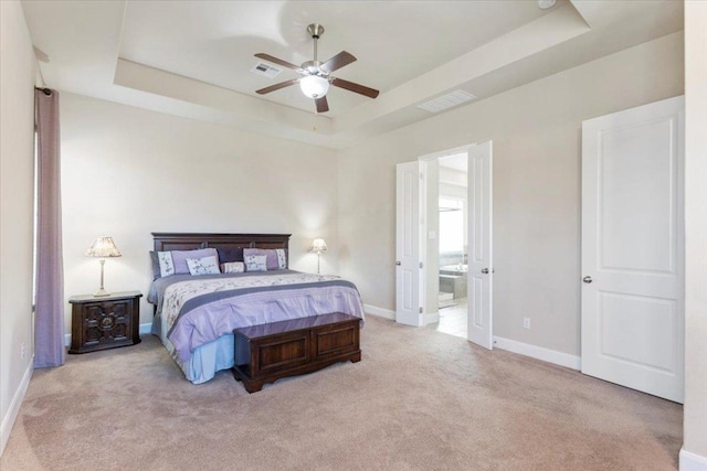 bedroom with a tray ceiling, baseboards, visible vents, and carpet floors