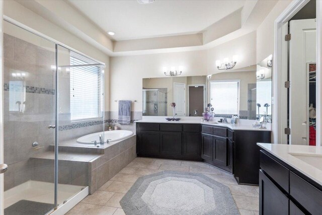 full bathroom featuring two vanities, a stall shower, a sink, tile patterned flooring, and a bath