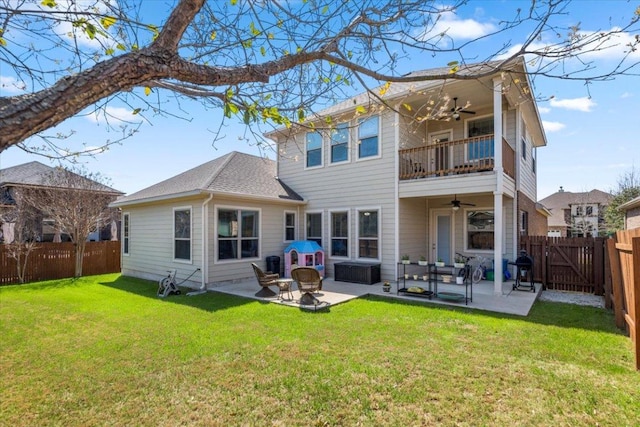 back of house featuring a ceiling fan, a fenced backyard, a yard, a balcony, and a patio area