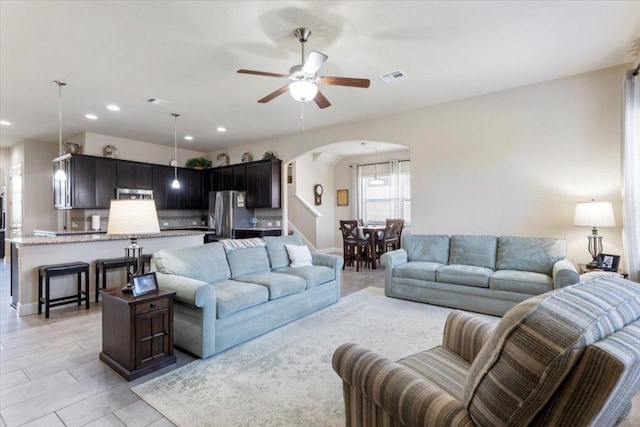 living area with recessed lighting, visible vents, arched walkways, and a ceiling fan