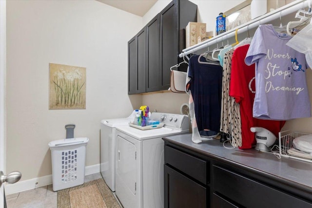 washroom featuring washer and dryer, baseboards, cabinet space, and light tile patterned floors