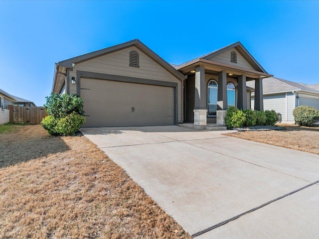 view of front of property featuring a garage, concrete driveway, and fence