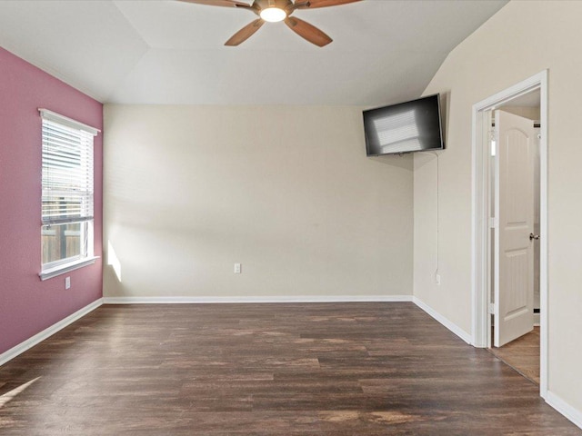 empty room featuring wood finished floors, ceiling fan, baseboards, and vaulted ceiling