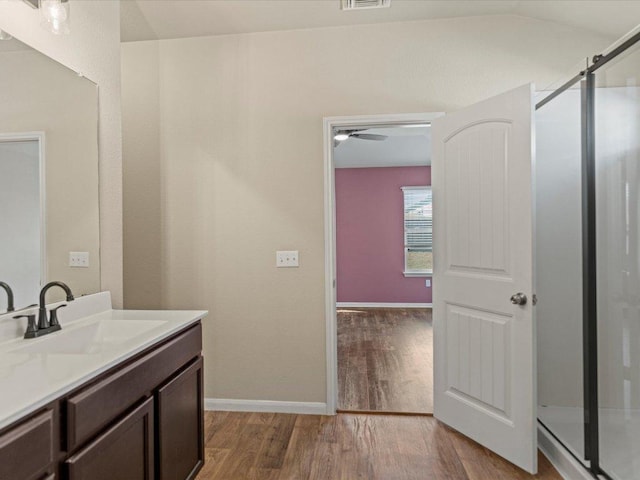 full bath featuring a stall shower, visible vents, wood finished floors, and vanity