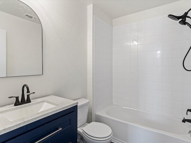bathroom featuring visible vents, toilet, shower / bathing tub combination, a textured wall, and vanity