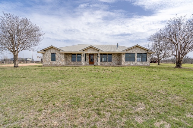 single story home featuring stone siding, metal roof, and a front lawn