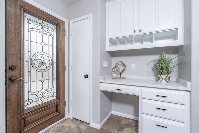 entrance foyer with baseboards and built in desk