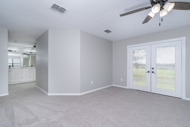 empty room featuring visible vents, light colored carpet, and french doors